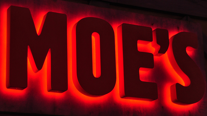 A lit sign for Moe's